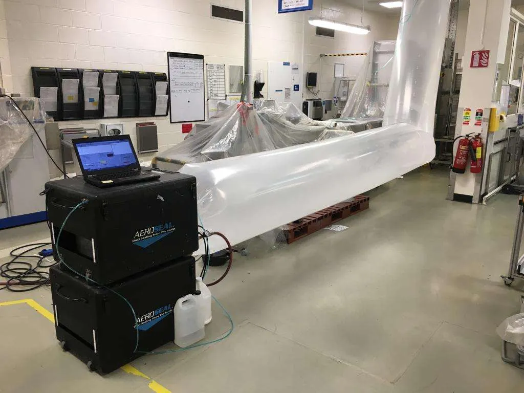 Aeroseal rig on site: the laptop reads live duct-leakage while the duct system is pressurized and sealed from the inside